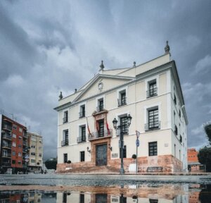 Vista del Ayuntamiento de Paterna con cielo nublado y reflejo en el agua