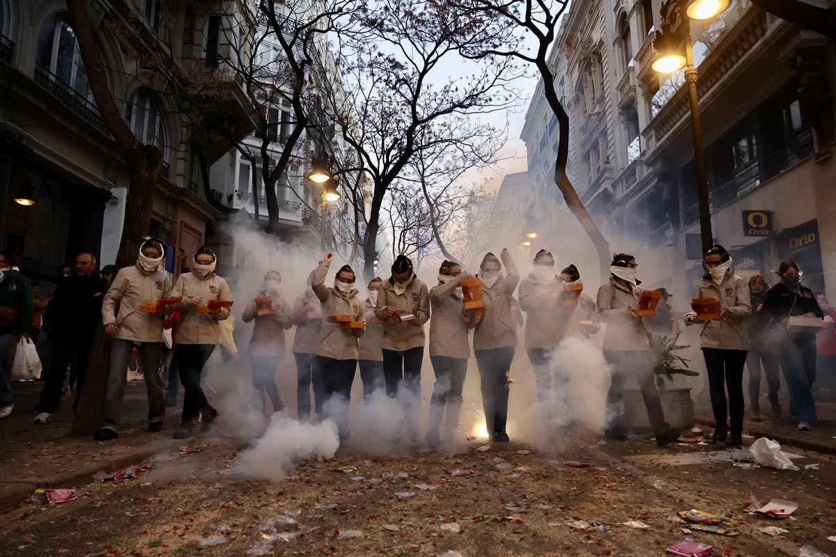 Grupo de personas en la calle durante una celebración con humo y luces
