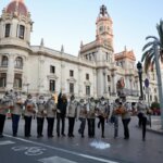 Grupo de personas celebrando en la calle frente a un edificio histórico en Valencia
