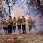 Grupo de personas en una celebración con humo y fuegos artificiales