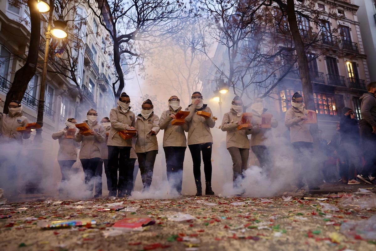 Grupo de personas en una celebración con humo y fuegos artificiales