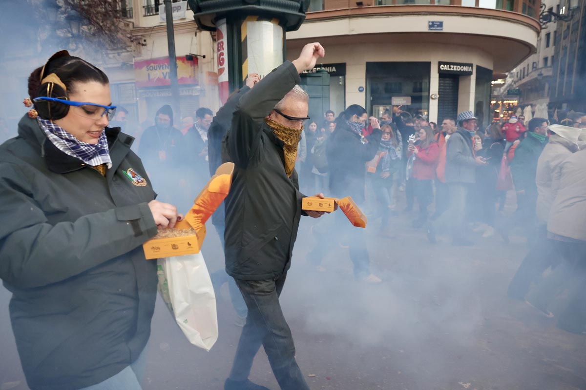 Personas celebrando con cajas y humo en la calle