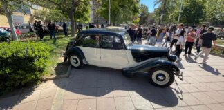 Vehículo clásico en la concentración de Moncada con asistentes alrededor.