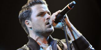 Dani Martín cantando en un concierto con micrófono en mano