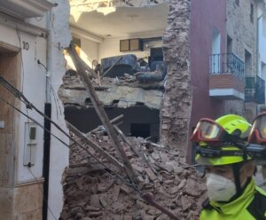 Derrumbe de una vivienda en Puçol con escombros visibles y un rescatista