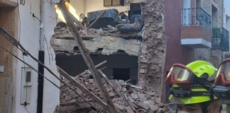 Derrumbe de una vivienda en Puçol con escombros visibles y un rescatista