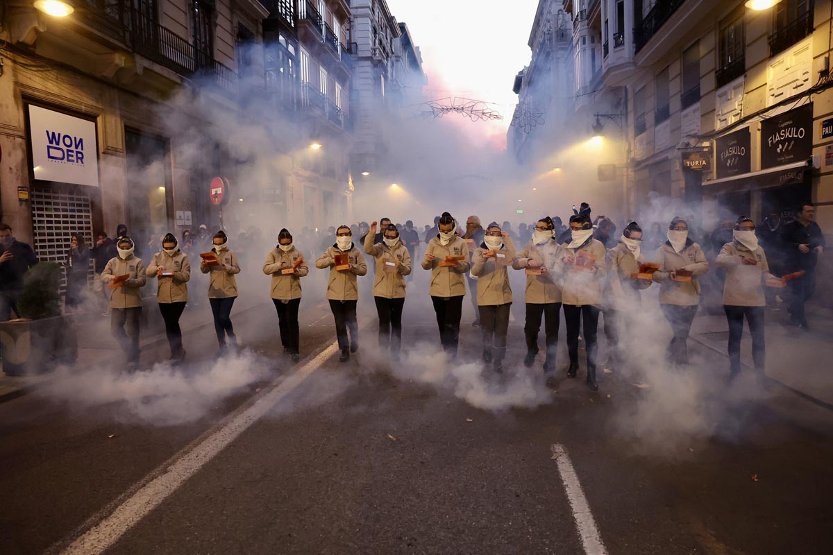 Grupo de personas en un desfile con humo en la calle