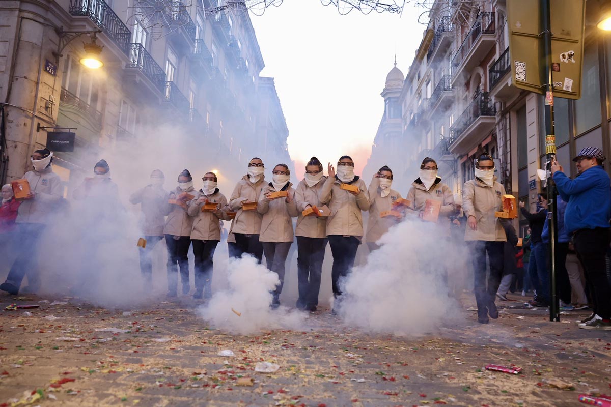 Grupo de personas en un desfile festivo con niebla en la calle