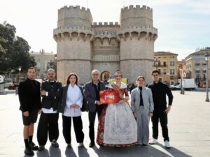 Grupo de personas en las Torres de los Serranos con cartel del espectáculo fók