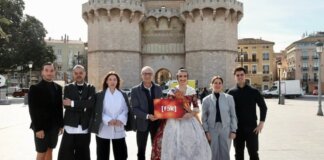 Grupo de personas en las Torres de los Serranos con cartel del espectáculo fók