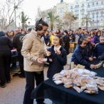 Personas en un evento comunitario recibiendo comida y bebida