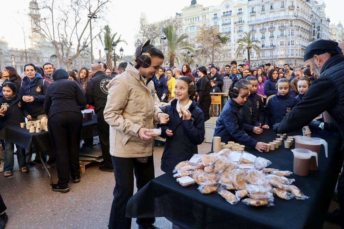 Personas en un evento comunitario recibiendo comida y bebida