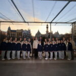 Grupo de bailarinas posando en un evento al atardecer.