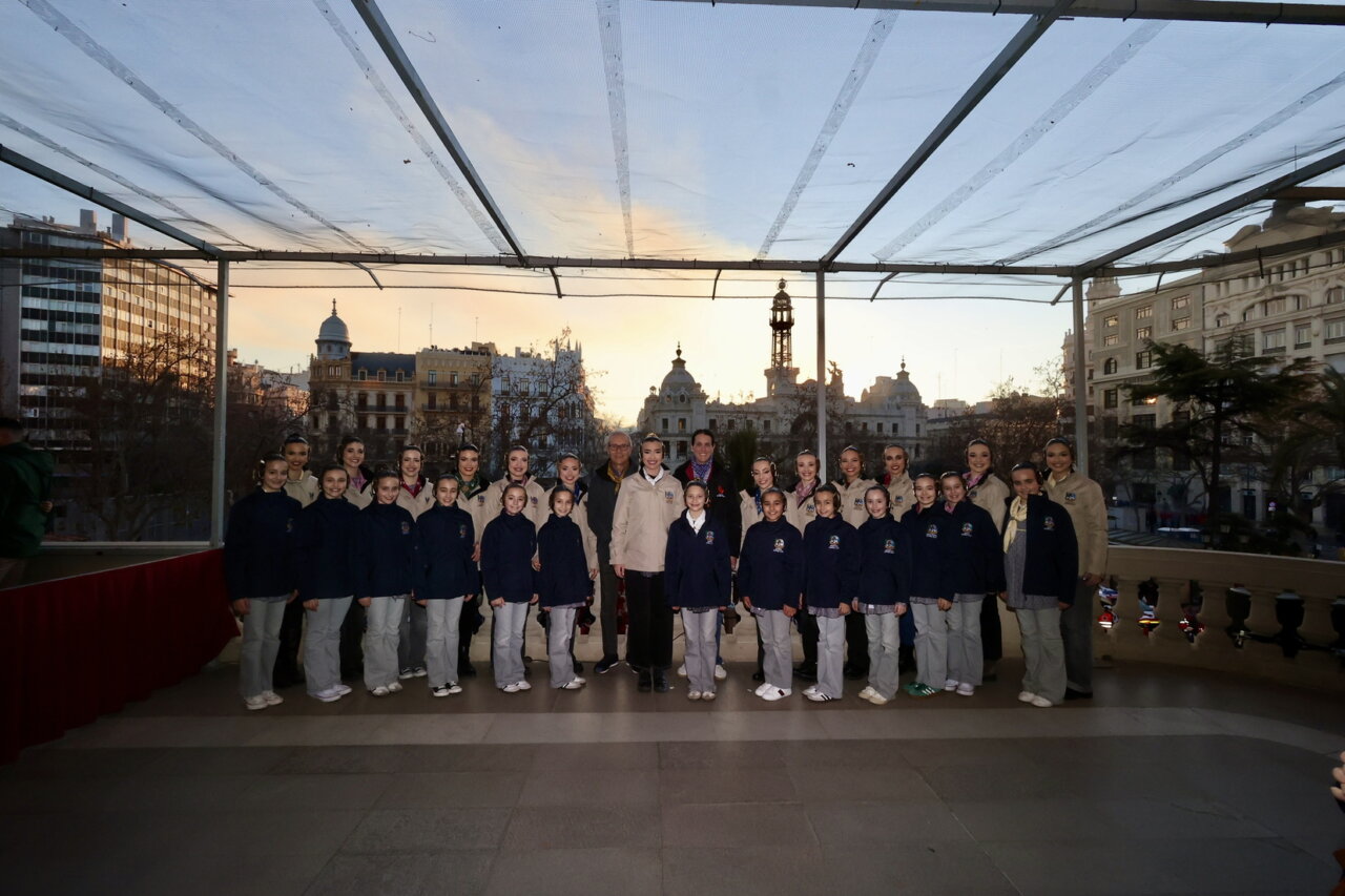 Grupo de bailarinas posando en un evento al atardecer.
