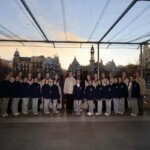 Grupo de bailarinas posando en un evento al atardecer