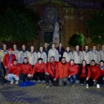 Grupo de personas posando en la noche con chaquetas de colores