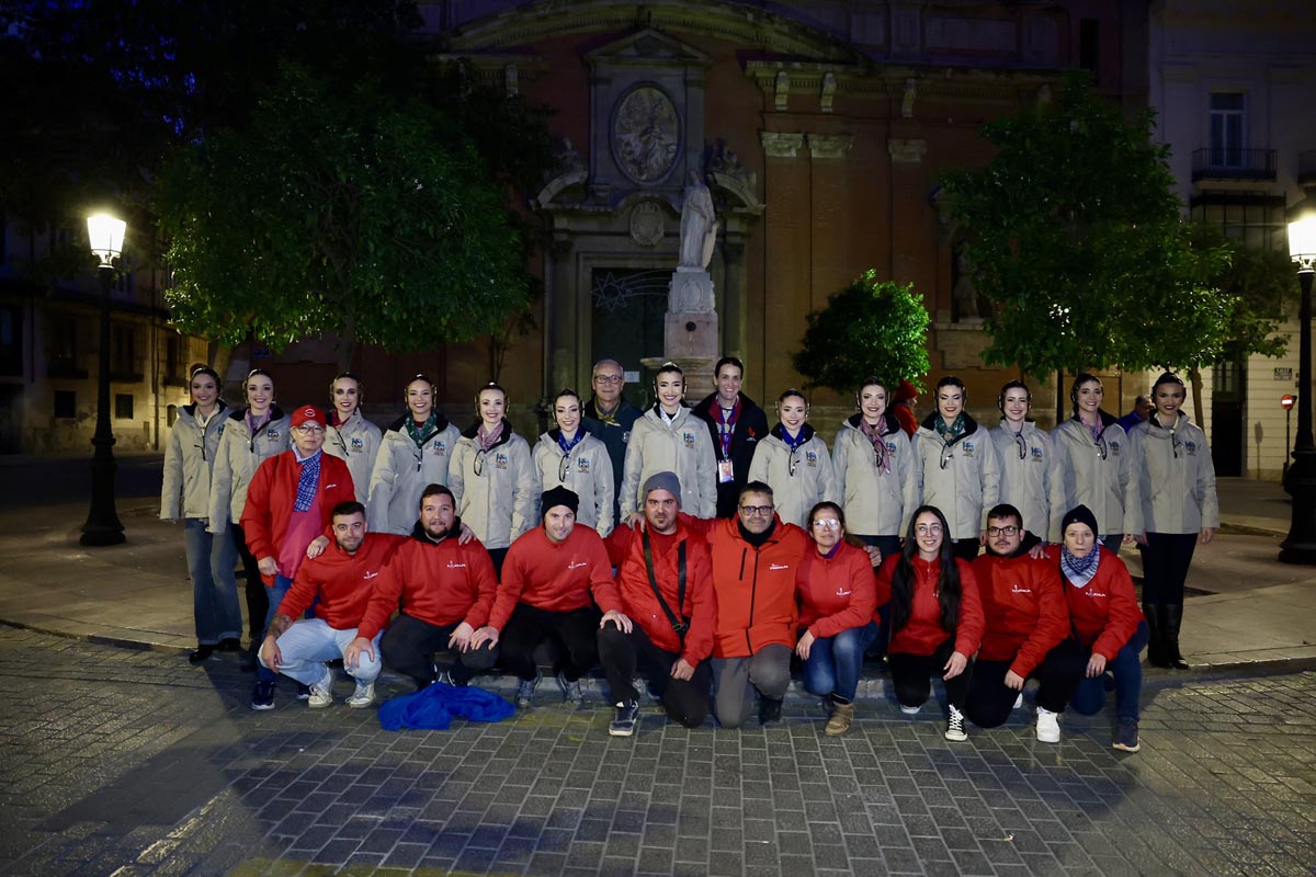 Grupo de personas posando en la noche con chaquetas de colores
