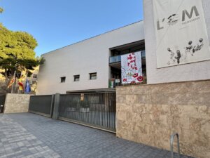 Fachada del IES l'Om en Picassent con banderas y mural