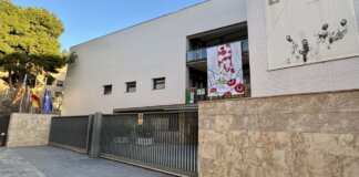 Fachada del IES l'Om en Picassent con banderas y mural