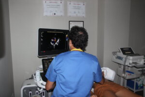 Médico realizando ecocardiografía a un paciente en consulta