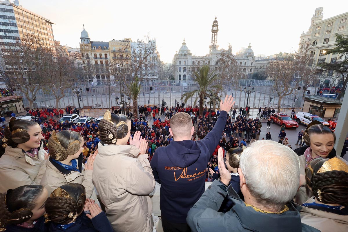 Multitud en celebración con personas saludando desde un balcón en Valencia