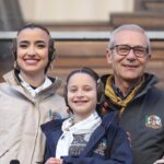 Tres personas sonriendo en un evento familiar al aire libre