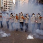 Grupo de personas en una manifestación con humo y fuegos artificiales
