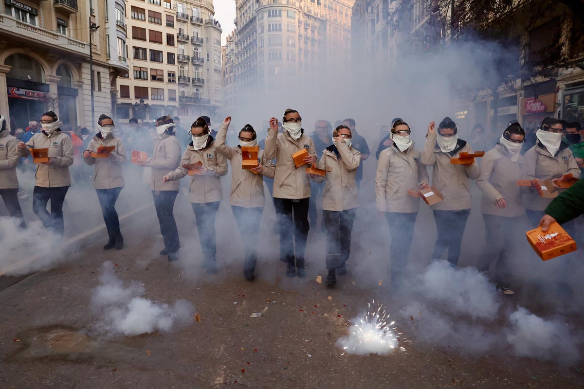 Grupo de personas en una manifestación con humo y fuegos artificiales