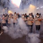 Grupo de personas en una manifestación con humo en la calle