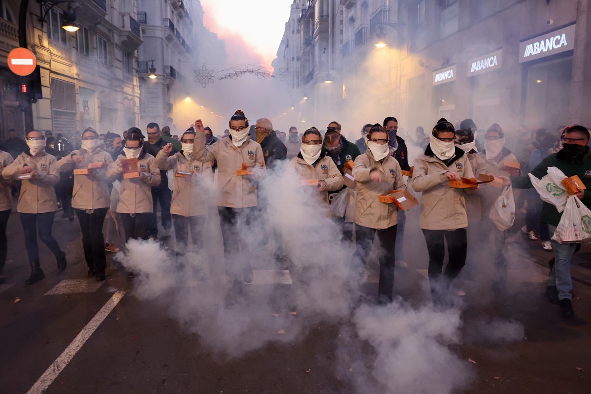 Grupo de personas en una manifestación con humo en la calle