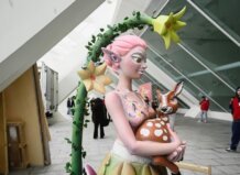 Escultura de una figura femenina sosteniendo un ciervo en una exposición