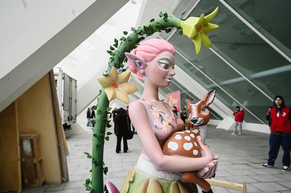 Escultura de una figura femenina sosteniendo un ciervo en una exposición