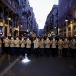 Grupo de personas con bandejas en una manifestación en la calle.