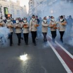 Grupo de personas en una manifestación con fuegos artificiales