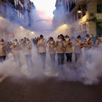 Grupo de personas en una manifestación con humo en la calle
