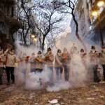 Grupo de personas en una manifestación con humo y cajas en la mano