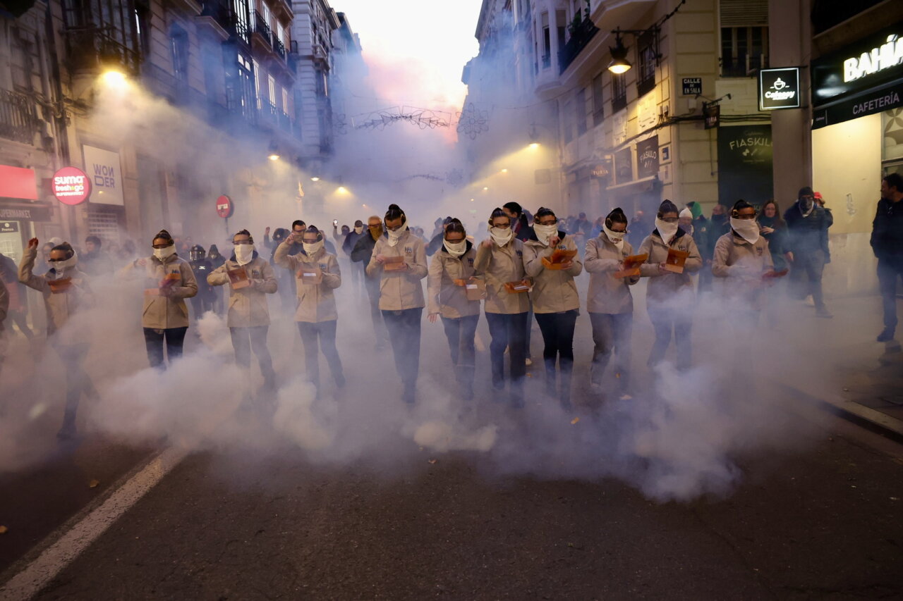 Grupo de personas en una manifestación con humo en la calle
