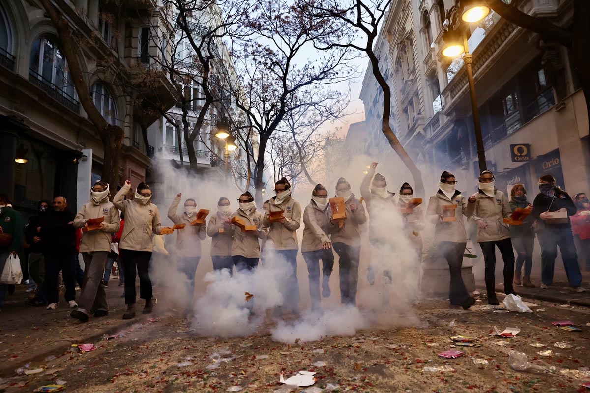 Grupo de personas en una manifestación con humo y cajas en la mano