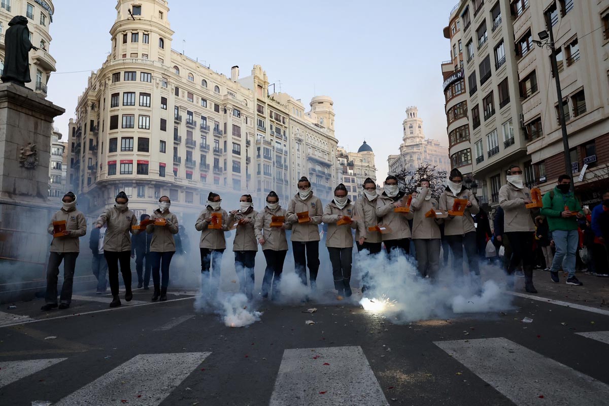 Grupo de personas en una manifestación con fuegos artificiales en Valencia