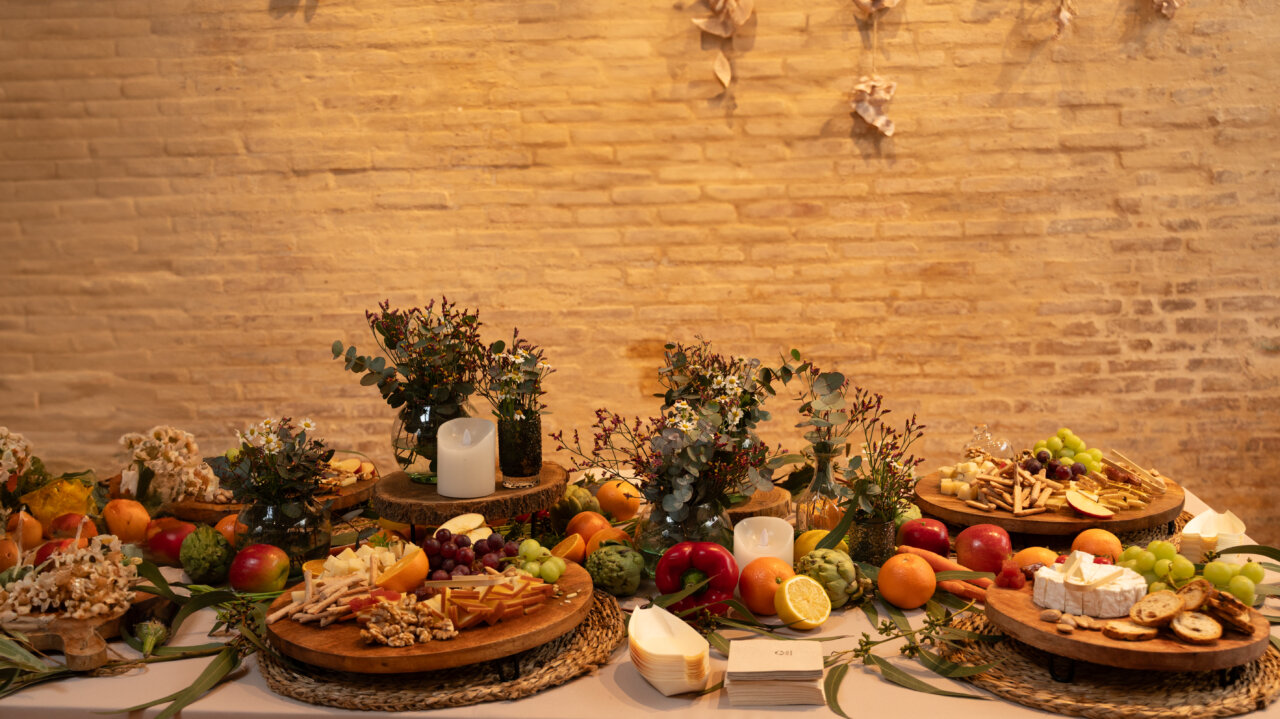 Mesa decorada con frutas frescas y quesos en un evento agrícola