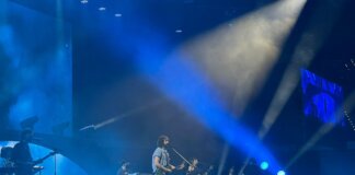 Mikel Izal actuando en el Roig Arena con luces azules y banda