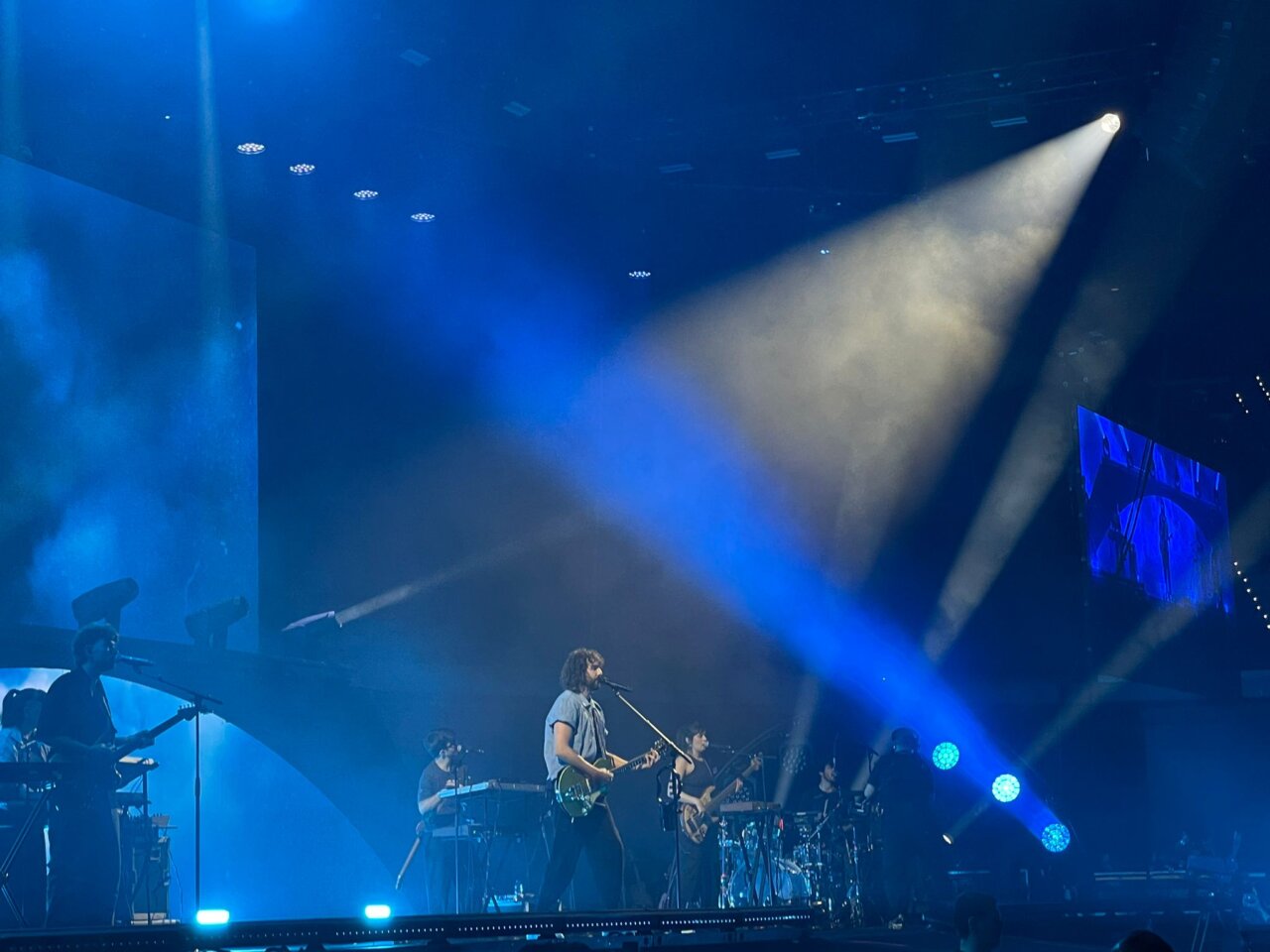 Mikel Izal actuando en el Roig Arena con luces azules y banda