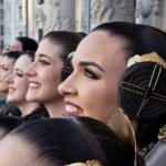 Mujeres con trajes tradicionales sonriendo en un evento cultural