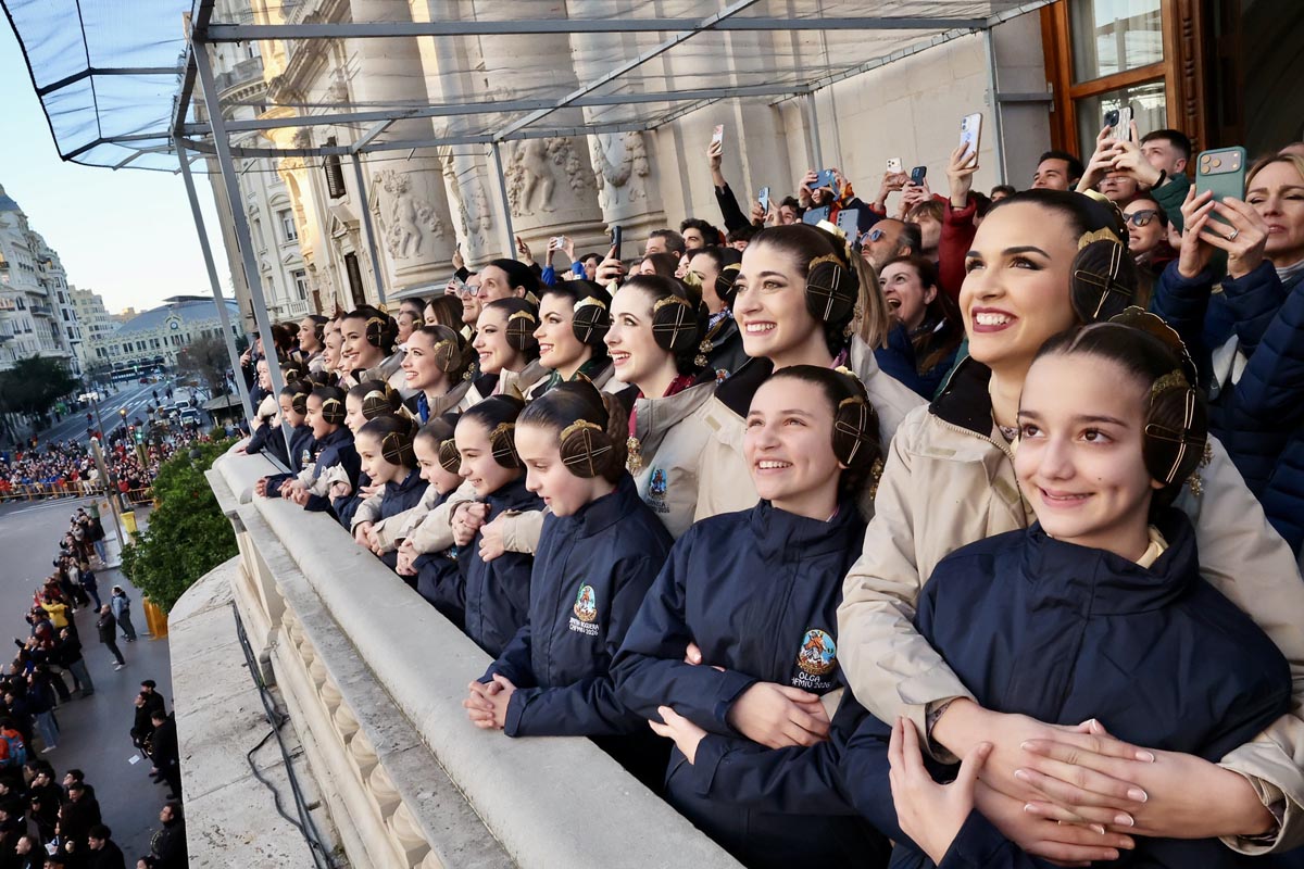 Grupo de mujeres sonriendo desde un balcón durante un evento