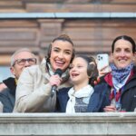 Mujeres sonriendo mientras sostienen un micrófono en un evento