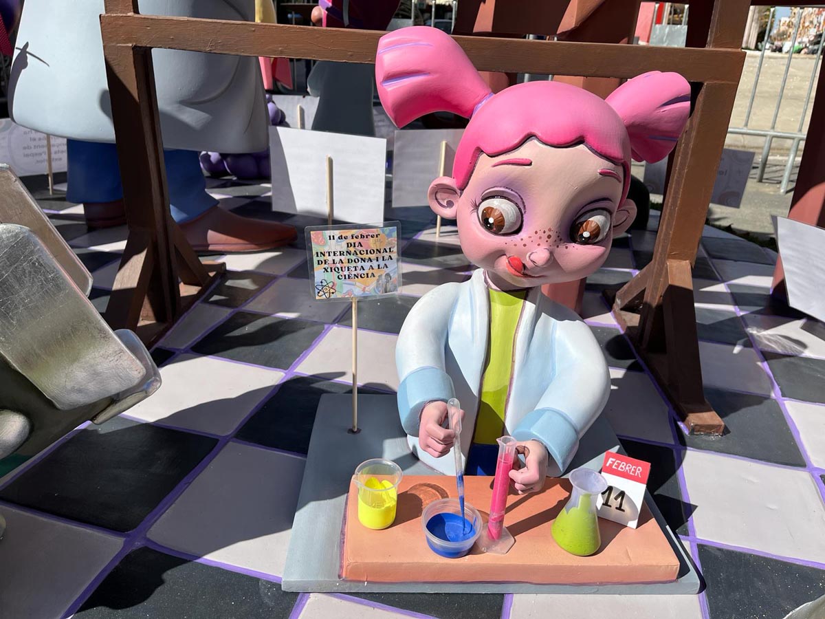 Mural representando a una niña científica en un taller fallero.