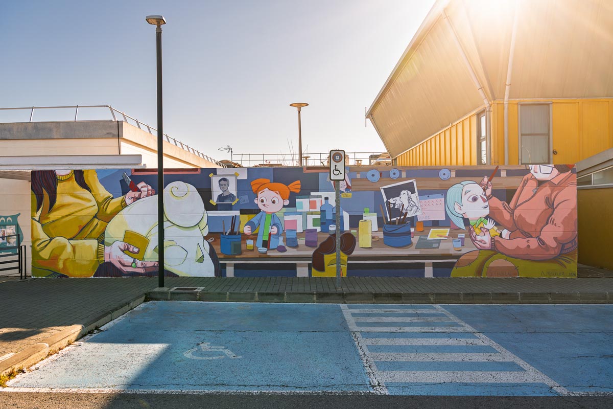 Mural en la UPV que representa a artistas falleras trabajando en un taller.