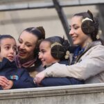 Niñas y mujeres con trajes tradicionales sonriendo en un evento