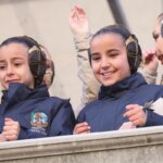 Niñas con trajes tradicionales sonriendo y disfrutando en un evento