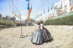 Dos falleras en Paiporta durante las Fallas 2026 con decoraciones festivas